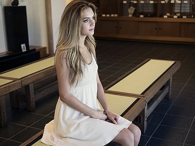 woman in white sleeveless dress sitting on white wooden chair thumbnail