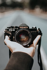 shallow focus photography of person holding Yashica FX-3 SLR camera thumbnail