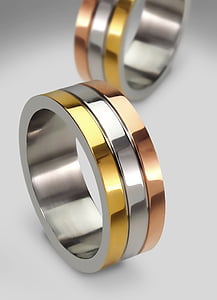 two gold-and-silver-colored rings on white panel thumbnail