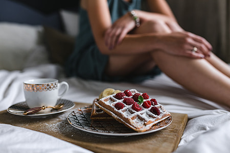 Breakfast in bed - waffles with raspberries and cup of coffee on the tray thumbnail