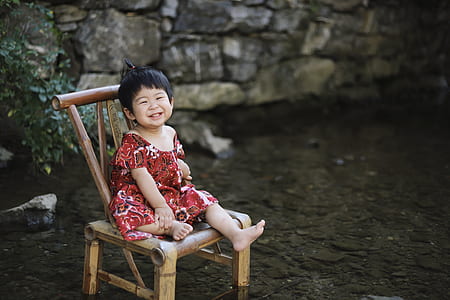 girl sitting on brown wooden chair while smiling thumbnail