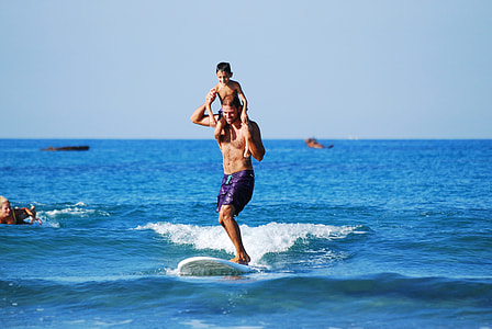 man and son carrying shoulder riding surfboard during daytime thumbnail