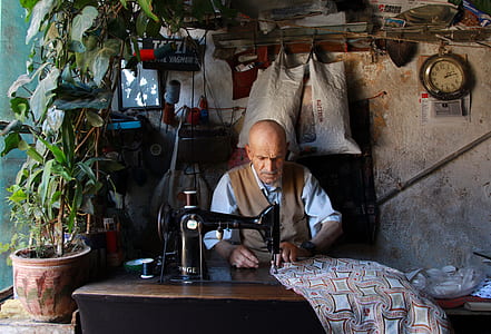 man wearing brown vest sewing thumbnail