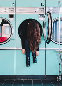 woman sitting on front-load washing machine thumbnail