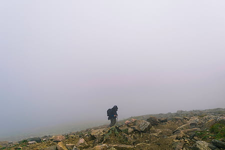 person on mountain with rocks and fog thumbnail