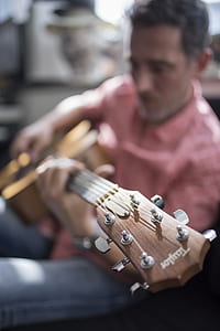 selective focus photo of man playing guitar thumbnail