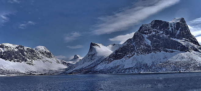 snow-covered mountains near body of water during daytime thumbnail