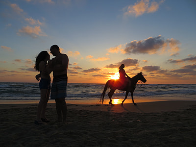 silhouette of man and woman standing beside the seashore thumbnail