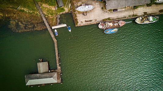 Bird's Eye View of Boat Near Dock on Calm Body of Water thumbnail