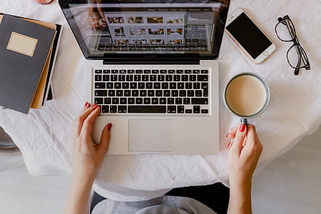 A woman works at a desk with a laptop and a cup of coffee thumbnail