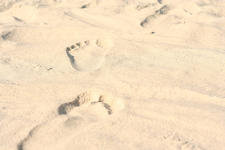 person foot print on white sands thumbnail