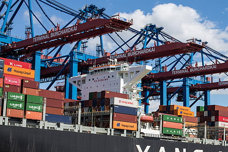 assorted-color cargo trailers on ship at daytime thumbnail