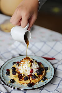 person pouring syrup on pancake filled with fruits thumbnail