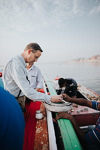 man reaching man's hand on boat thumbnail