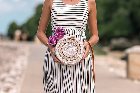 Woman Wearing White And Black Striped Sleeveless Dress Holding Round Crochet Bag thumbnail