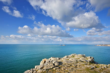 rock formation near body of water at daytime thumbnail