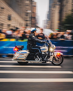 panning photo of man in black jacket riding beige motorcycle thumbnail