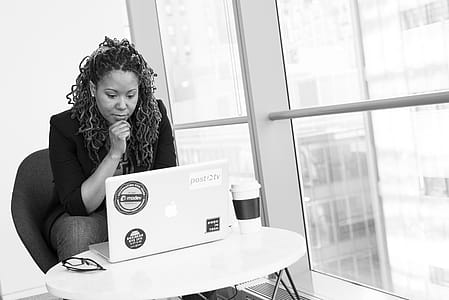 Grayscale Photo of Woman Facing Macbook thumbnail