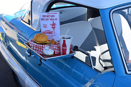 pastry and Coca-Cola drinking cup on tray hanged on blue car's window thumbnail