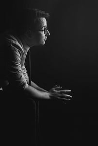 greyscale photography of sitting on chair while wearing eyeglasses thumbnail