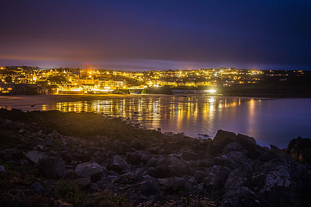 photo of city near body of water during nightime thumbnail