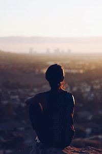 selective photography of woman sitting on rock thumbnail