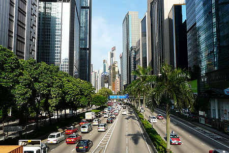 aerial view photography of vehicle lot on roadway between buildings during daytime thumbnail