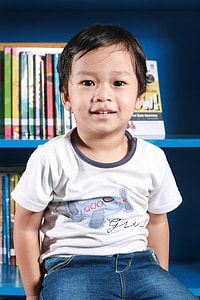 boy in white shirt and blue pants sitting on shelf thumbnail
