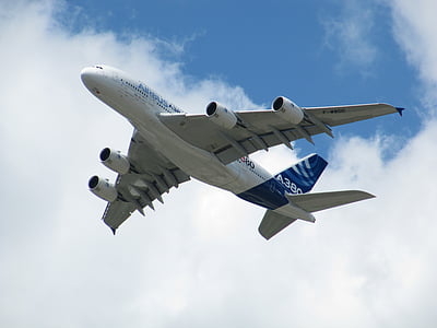 low angle photo of white and blue airplane flying in sky at daytime thumbnail