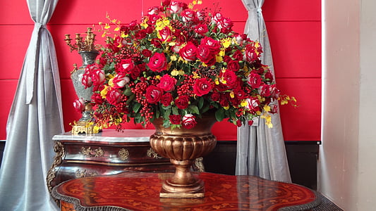 red and yellow flowers in brown vase on table thumbnail