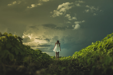 woman wearing sleeveless dress standing on green grass field thumbnail