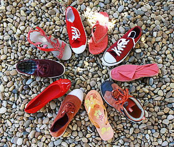 assorted pairs of footwear on pebble stones thumbnail