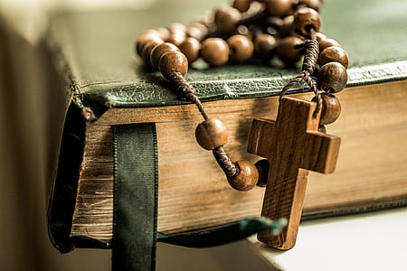 shallow focus photography of brown rosary on book thumbnail