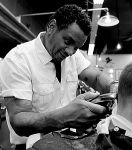 grayscale photo of man holding black hair trimmer thumbnail