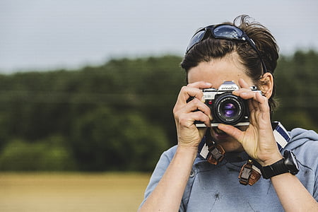 man holding grey and black camera thumbnail