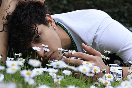 man lying on green and white grass field thumbnail