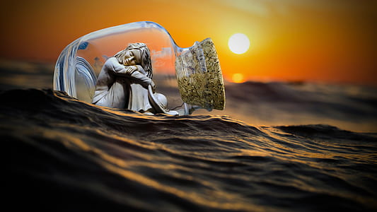 woman sitting inside cork covered bottle floating on water against sunset thumbnail