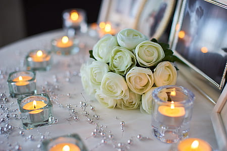 white petaled flower bouquet near clear glass candle holders thumbnail
