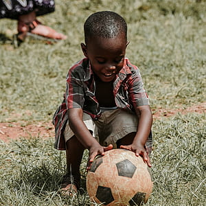 boy wearing plaid shirt holding soccer ball thumbnail