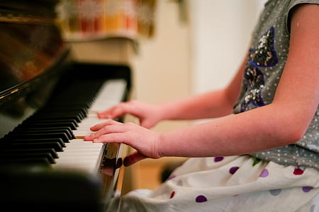 person playing brown and white piano thumbnail