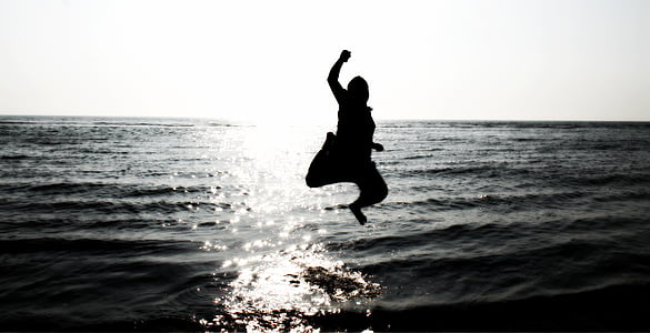 silhouette of person jumping on body of water thumbnail