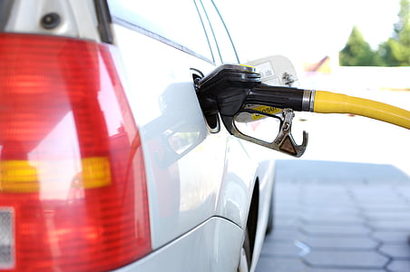 white vehicle filling gas tank using gasoline pump thumbnail