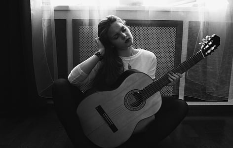woman using acoustic guitar during daytime thumbnail