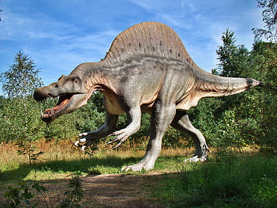 brown dinosaur walking on grass thumbnail