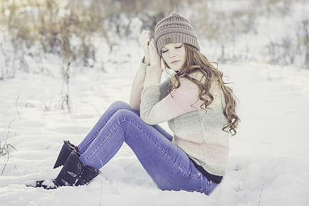 woman in grey sweater and blue jeans sitting on ground during daytime thumbnail