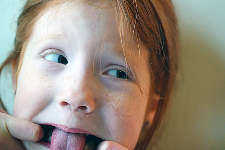 girl leaning on white painted wall opening tongue thumbnail