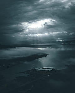 arolie photo of body of water under glimmer of sunlight through clouds thumbnail