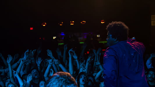 man in purple dress shirt facing in audience thumbnail