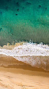 brown ocean sand with ocean wave during daytime thumbnail