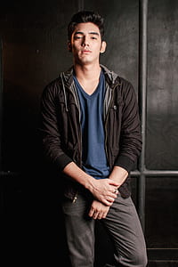 man wearing black zip-up jacket and blue V-neck top thumbnail